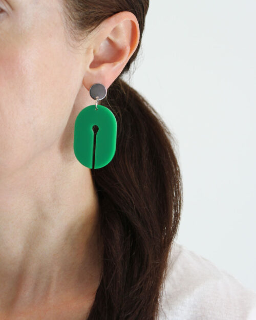 Une Femme Acrylic Earring in transparent green colour shown being worn by dark haired woman.