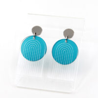 Pon Pon Through the Arch earrings in clear etched and frosted teal acrylic