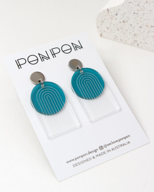 Pon Pon Through the Arch earrings in clear etched and frosted teal acrylic