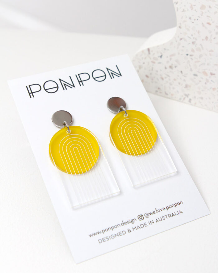 Pon Pon Through the Arch earrings in clear etched and frosted yellow acrylic